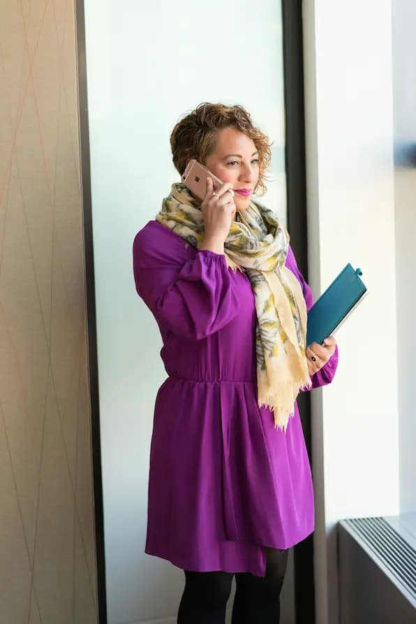 Femme professionnelle utilisant smartphone et tablette dans un environnement de bureau moderne